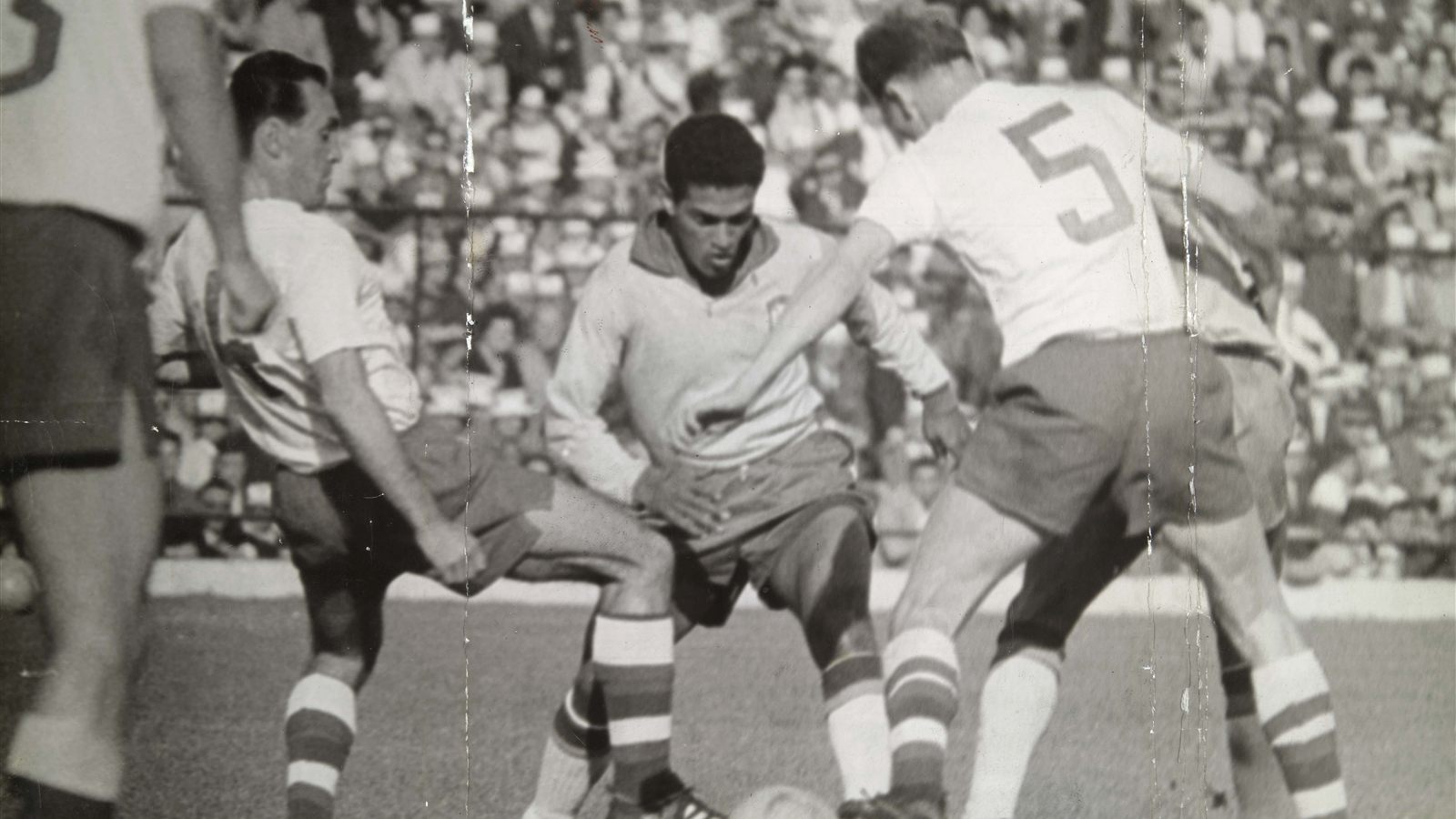 Garrincha carries the ball surrounded by three defenders during a 1962 World Cup match in Chile