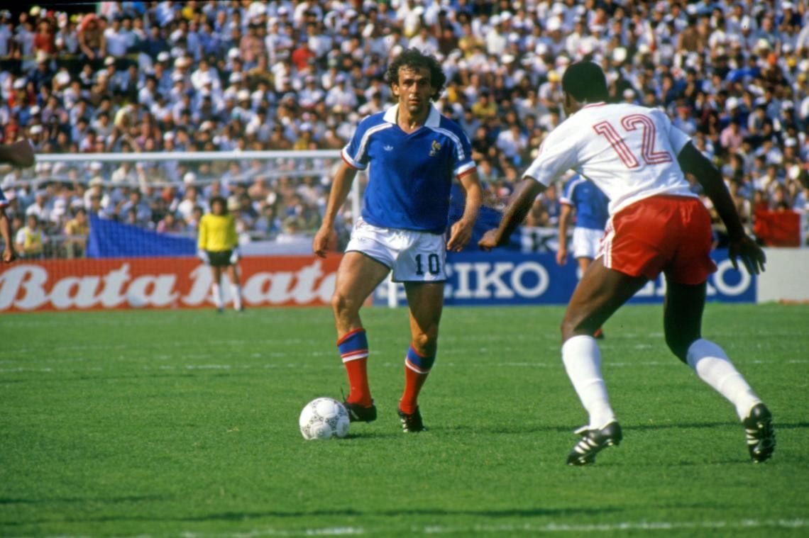 Michel Platini in France's blue number 10 shirt with the ball, closed down by a Canada player at the 1986 World Cup