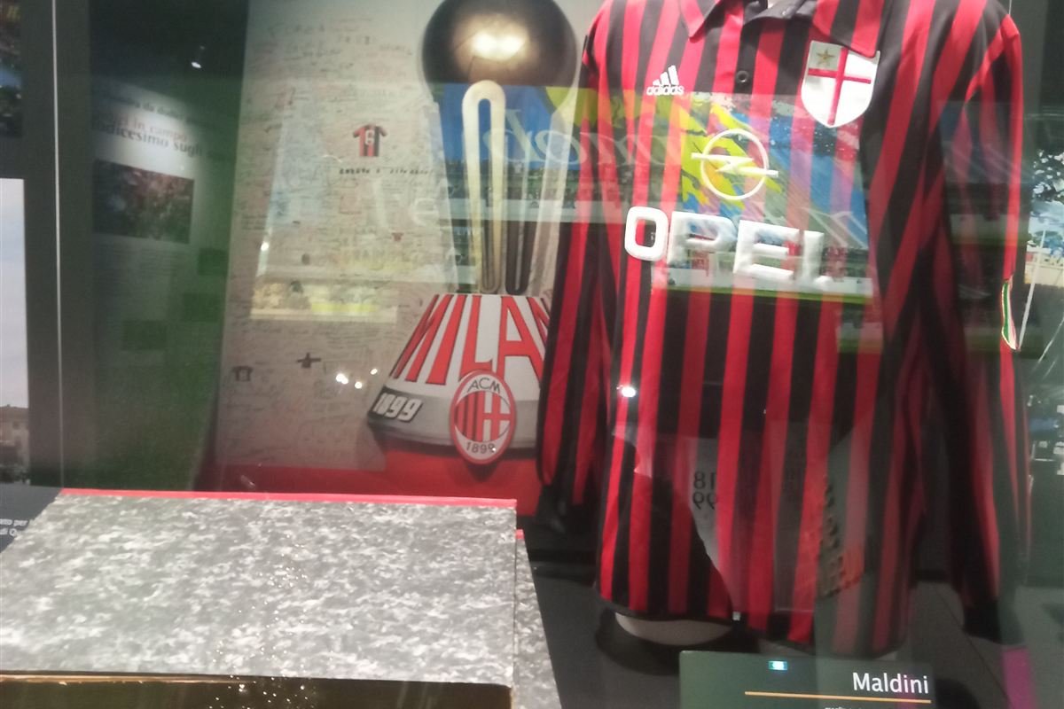 The AC Milan 1999–2000 centenary shirt displayed at the San Siro Museum with a label reading Maldini