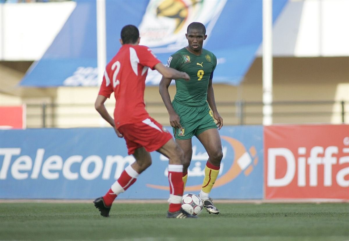 Samuel Eto'o in Cameroon's green number 9 shirt with the captain's armband, facing a Morocco defender in November 2009